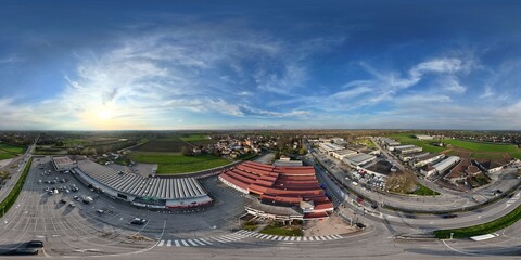 Castelvetro Piacentino commercial area with warehouses and parking lots during sunset