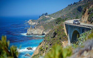 Scenic coastal road, car on bridge, ocean views, lush hills