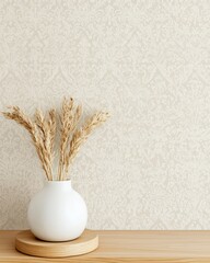 A minimalistic interior scene featuring a white vase filled with dried grass on a wooden surface against a subtle patterned wall, creating a serene and stylish atmosphere.