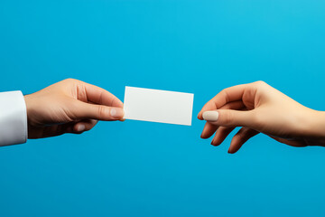Obraz premium Business Card Exchange Between Two Hands on Blue Background