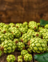 Fototapeta premium Fresh green hop cones scattered on rustic wooden table, wet, countryside