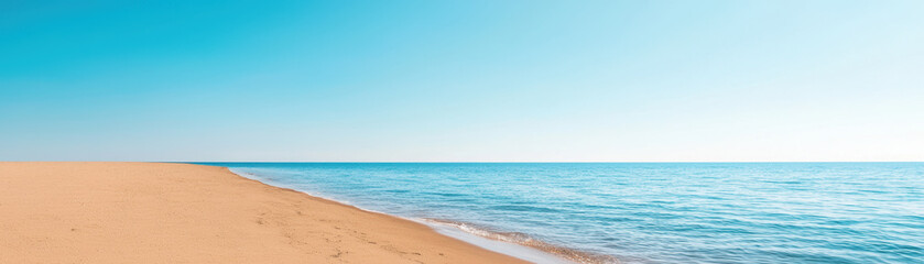 Obraz premium serene beach landscape with golden sand and calm blue waters under clear sky evokes sense of tranquility and peace