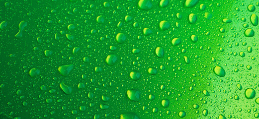 green background with texture of rain drops on a metal surface closeup