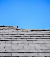 Naklejka premium Grey asphalt shingles contrast vibrantly against a clear azure sky, sky, texture