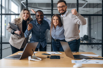 Happy, celebrating success. Professional workers are in the modern office together
