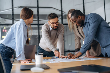 Together by the table. Professional workers are in the modern office