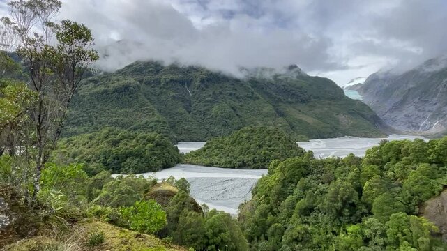 Powerful blue glacier tongue and meltwater river of Franz Josef Glacier and lush rainforest from Sentinel Rock Viewpoint, Westland Tai Poutini National Park, West Coast, South Island, New Zealand