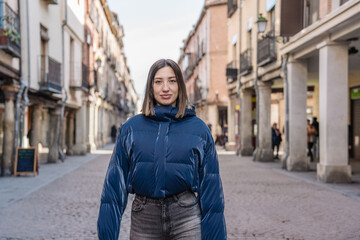 Fototapeta premium Young woman walking in a pedestrian street in a european city center