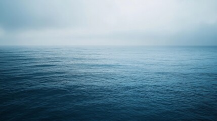 Obraz premium Endless ocean stretches under a pale, tranquil sky, embodying simplicity and infinite serenity, with no land in sight.