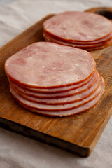 Organic Smoked Cold Cuts Deli Meat Ham on a wooden board, side view.