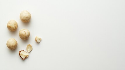 Macadamia nuts, whole and broken, on white background; food photography, nutrition