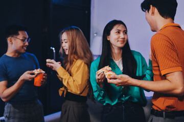 Happy young friends group having lunch at home. Asia family party eating pizza food and laughing enjoying meal while sitting at dining table together at house. Celebration holiday and togetherness.