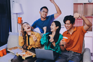 Happy young friends group having lunch at home. Asia family party eating pizza food and laughing enjoying meal while sitting at dining table together at house. Celebration holiday and togetherness.