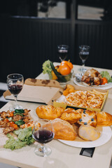 Asian office colleagues and friends enjoy a daytime BBQ with pizza and beer, celebrating Halloween and cheering for their favorite soccer team, creating a lively atmosphere filled with joy.