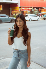 Fototapeta premium young woman in the street holding drink