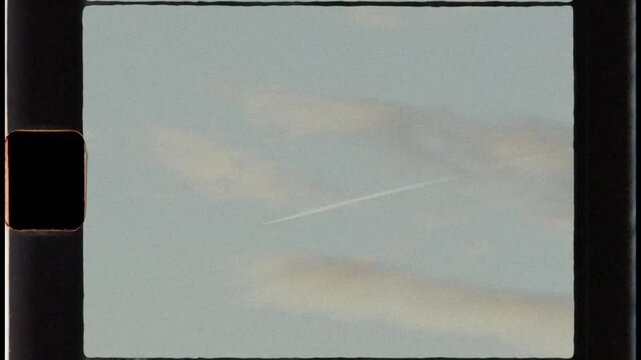 Super 8 film look: parisian rooftops at sunset with airplane trail