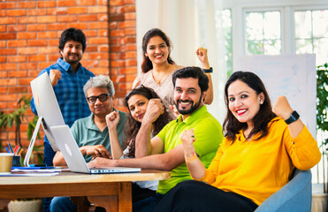Young Indian entrepreneurs cheerfully celebrating success at a startup office after hard work