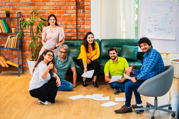 Fototapeta premium Indian Young professionals discussing ideas, planning a business project with documents in office