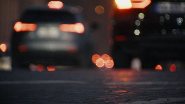 Blurred city traffic at dusk showing paving stones
