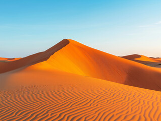 "Golden Sand Dunes in Desert Landscape with Vibrant Orange Hues and Clear Blue Sky
