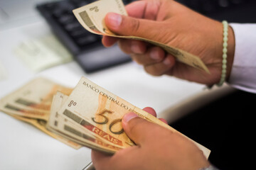 Businessman counting and exchanging money - Brazilian Real - Reais.