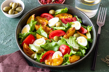 Salad with potatoes, tomatoes, olives and eggs. Healthy food. Vegetarian food.