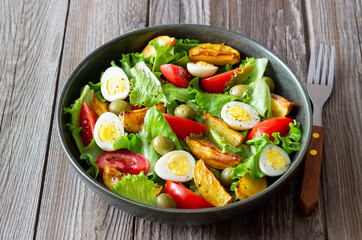 Salad with potatoes, tomatoes, olives and eggs. Healthy food. Vegetarian food.