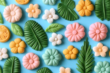 Fototapeta premium Colorful assortment of flower and leaf shaped decorations on a blue background for creative projects and parties
