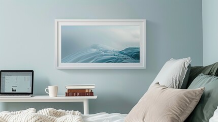 A white rectangular frame displayed in a bedroom above a side table with a cup, a laptop, and a pile of books. HD 8K mockup wallpaper Photographic Image