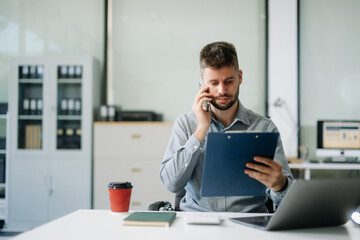 Fototapeta premium Confident businessman working on finance analysis with a tablet and laptop at office desk. professional workplace concepts..