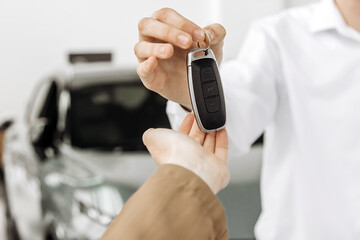 The completion of a car purchase or rental deal, with the handover of keys. Concept the final step of a seamless car buying, selling, or test-driving experience, highlighting customer satisfaction.