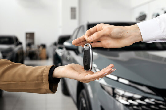 The completion of a car purchase or rental deal, with the handover of keys. Concept the final step of a seamless car buying, selling, or test-driving experience, highlighting customer satisfaction.