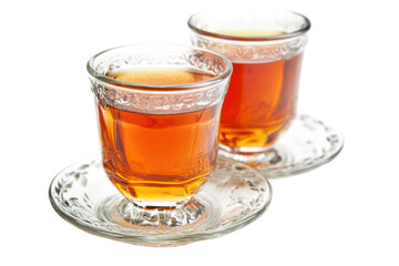 Two glasses of amber liquid on decorative glass saucers against on Isolated on white transparent background
