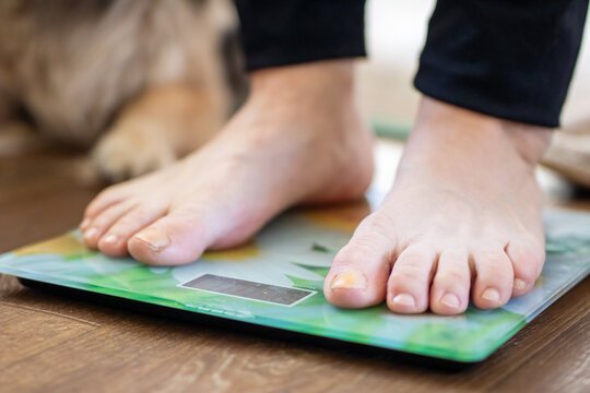 A person is currently standing on a scale, with their feet placed on it