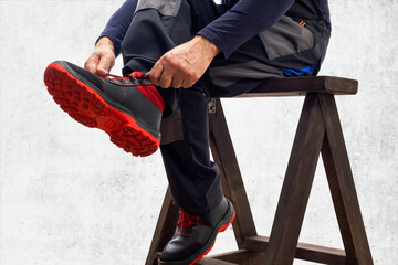 Close-up of worker putting boots. Safety work concept