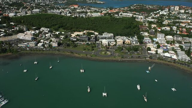 Aerial pullout revealing coastal city of Noumea, New Caledonia on Orphanage Bay, or Baie de l&rsquo;Orphelinat, Mont Dore rising in background.