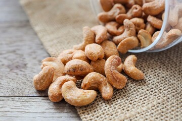Salted cashew nuts on wooden background	
