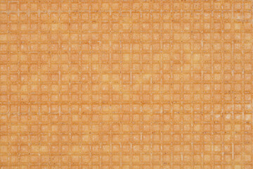 A close-up, full-frame shot of a wafer sheet texture, displaying its fine square grid pattern and light brown color