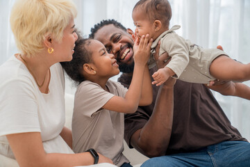 Obraz premium Happy family enjoying playful moments together in a bright living room during the day