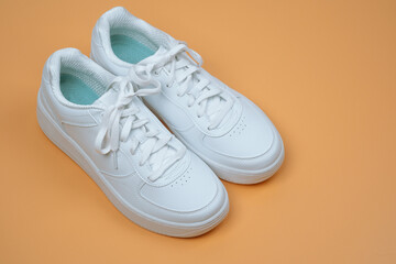 White Sneakers on Peach Background top view