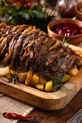 Roasted whole pork neck. Stuffed with onion slices. Served with baked potatoes.