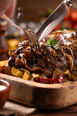 Roasted whole pork neck. Stuffed with onion slices. Served with baked potatoes.