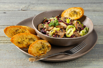 Spring salad with red beans and mushrooms. Served with croutons and garlic butter.