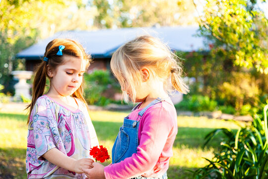 Two little girls in pink playing outside together