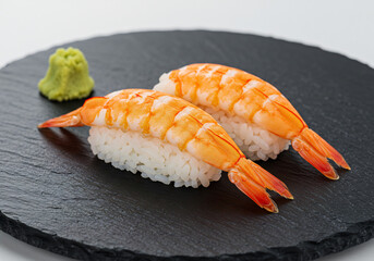 Two Cooked Shrimp Nigiri Sushi on a Dark Plate with Wasabi