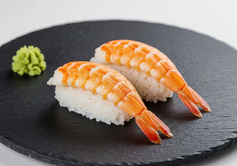 Two Pieces of Cooked Shrimp Nigiri Sushi on Black Slate Plate
