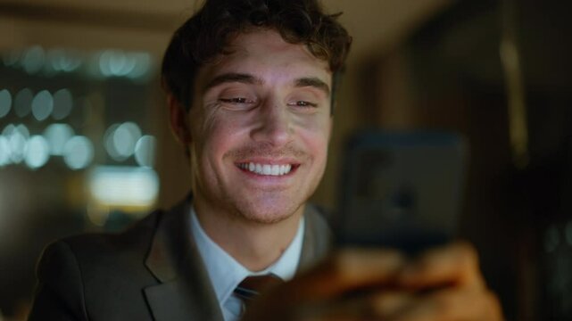 Late worker tapping smartphone screen browsing message at dark apartment closeup