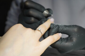 A skilled nail technician carefully applying gel polish to a client&rsquo;s nails in a professional beauty salon.