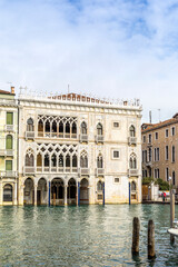 Venice, Italy - February 11, 2024: The Ca' d'Oro, a stunning white building with intricate Gothic architecture, reflects in the tranquil waters of the Grand Canal in Venice, Italy