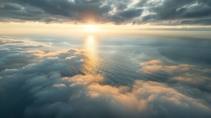 A breathtaking aerial view of the ocean at sunset, with clouds reflecting golden hues, creating a serene atmosphere
